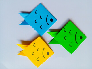 Yellow, blue and green fish origami isolated on white background.