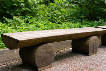 Rustic wooden bench on a path in a lush green forest, concept of nature, tranquility, outdoor...