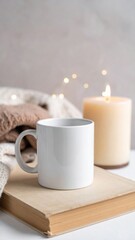 White Mug on Book with Candle and Knitwear