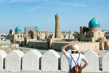 Young woman tourist looking in front of Bukhara city - Uzbekistan