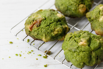 Closeup of fresh baked matcha cookies on white wooden background.