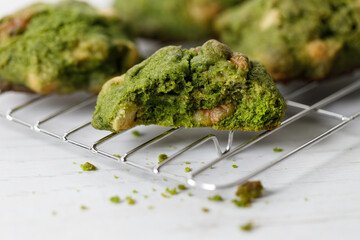 Closeup of fresh baked matcha cookies on white wooden background.