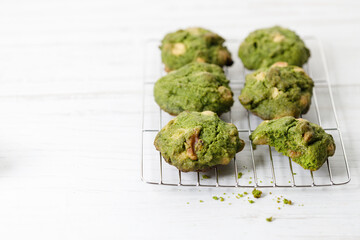 Closeup of fresh baked matcha cookies on white wooden background.