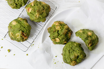 Closeup of fresh baked matcha cookies on white wooden background.