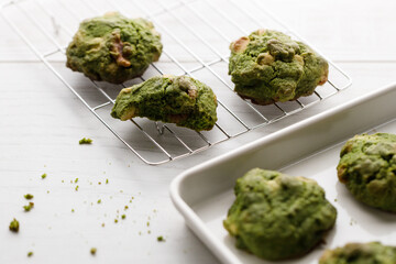 Closeup of fresh baked matcha cookies on white wooden background.