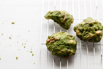 Closeup of fresh baked matcha cookies on white wooden background.