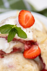 Juicy strawberries peek from inside soft dumplings, served with cold sour cream and mint leaves. A...