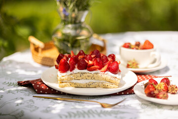 Outdoor picnic with homemade strawberry crepe cake and fresh berries. Sweet and rustic moment.