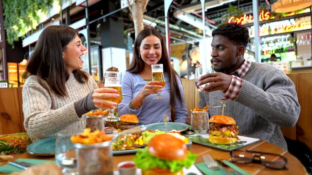 Friends toasting and drinking beer in restaurant