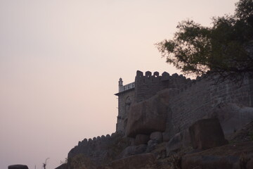 Obraz premium Ancient Minarets of Golconda Fort Overlooking Modern Hyderabad Skyline at Dusk