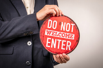 Rejection or Exclusion Concept with Do Not Welcome Sign Held by Businessperson