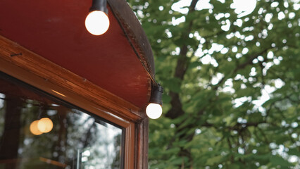 String lights hanging over cafe terrace with warm ambiance in urban space