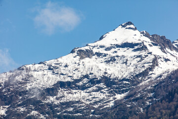 A mountain covered in snow with a blue sky in the background