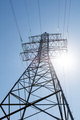 A tall power tower with wires and a clear blue sky