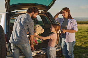Families gather for a delightful outdoor picnic, sharing smiles and laughter while a young girl...