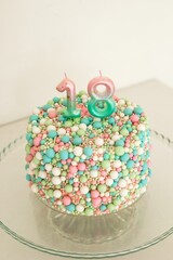Delightful 18th Birthday Cake Adorned with Colorful Sprinkles and Festive Candles in Pastel Colors