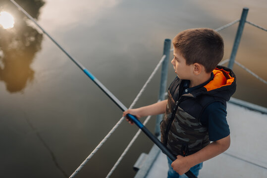 Young fisherman enjoying a peaceful sunset fishing on the pier