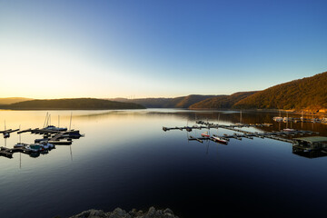 View of the Rursee at the dam near Heimbach-Schwammenauel. Landscape at the lake at sunset. Nature in the Eifel National Park.
