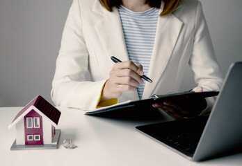 Beautiful real estate agent signs documents and gives home insurance advice Create a home purchase...