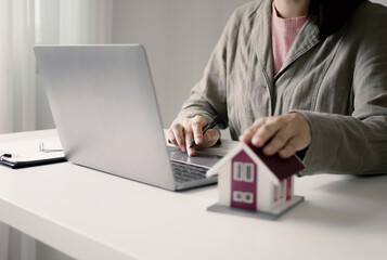 Beautiful real estate agent signs documents and gives home insurance advice Create a home purchase...