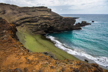 Scenic view of Green Sand Beach on Hawaii’s Big Island, featuring rare olive-green sand and...