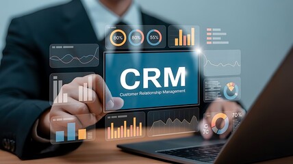 Man using laptop with crm interface and data visualizations overlayed