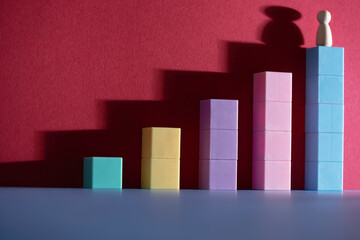 wood figurine  on top of colorful toy blocks