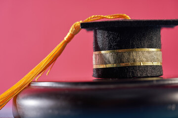 small mortarboard  on table against red background