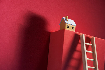 model house on top of block with step ladder lean on it.