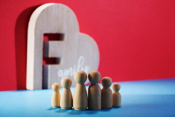 Group of wooden figures, father mother daughter, and son with decoration heart shape  with text family.
