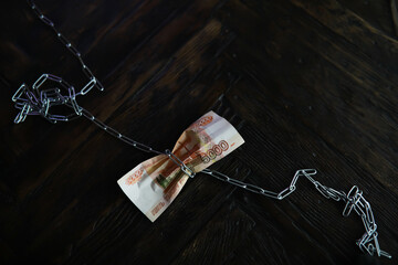 Chain-Tied Russian Rubles on Dark Wooden Surface - Economic Constraints Concept