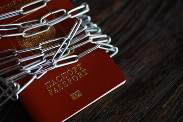 Russian Passport Secured with Chains and Paper Clips Symbolizing Travel Restrictions and Security