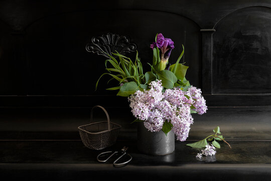 Vintage bouquet of late spring flowers with iris, lilacs, and bunnytail grass in a studio setting.