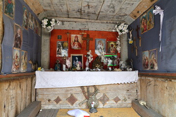 Interior of a small, aged The Olesnicki chapel with religious icons and decorations, on the trail...