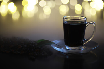 Fototapeta premium Elegant Glass Cup with Fresh Brewed Coffee and Coffee Beans on Dark Background