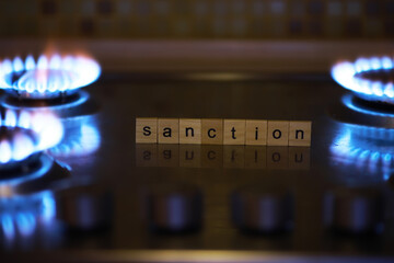 Sanction Concept with Scrabble Letters on a Gas Stove Burner Reflecting Economic Restrictions