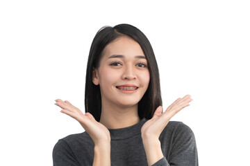 Smiling young woman showing excitement with hands raised in a cheerful gesture wearing a gray...