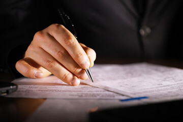 Businessman Signing Document with Pen in Hand for Legal Agreement or Contract