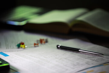 Close-Up of Study Desk with Open Book, Pen, and Colored Pushpins