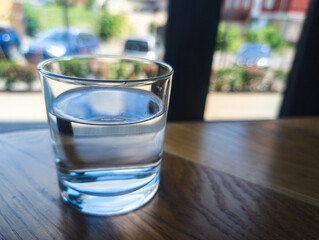 Glass of clean water on a table near a window with natural light