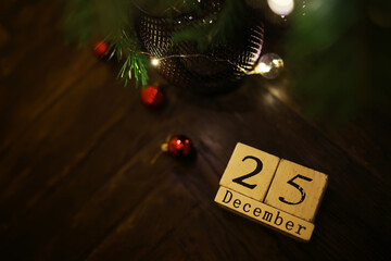 Wooden Calendar Blocks Showing December 25 Underdecorated Christmas Tree with Ornaments and Lights