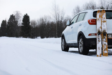 Winter Road Trip with SUV and Skis in Snowy Forest