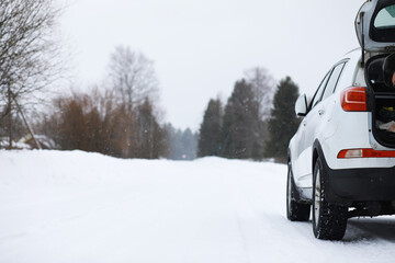 Snowy Road Winter Scene with Parked SUV and Open Trunk in Rural Area
