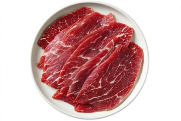 Thinly sliced, raw beef arranged neatly on a round, off-white plate, showcasing rich red marbling and visible grain