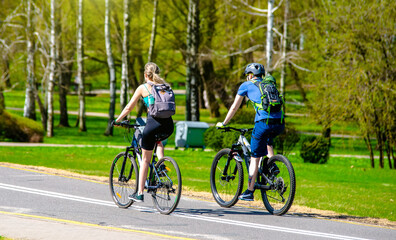 Fototapeta premium Cyclists ride on the bike path in the city Park 