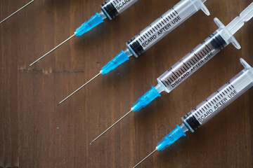Medical Syringes Lined Up on Wooden Surface for Vaccination and Healthcare Use