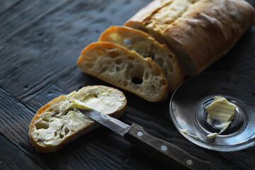 Freshly Sliced Artisan Bread with Butter Spread on Rustic Wooden Table