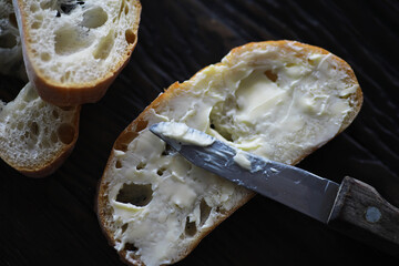 Freshly Sliced Rustic Bread with Butter on a Wooden Table - Close-Up Breakfast Image