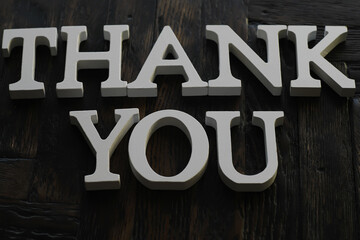 Thank You Sign in White Letters on Dark Wooden Background