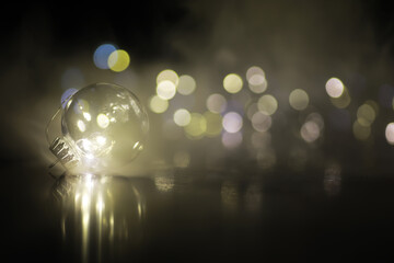 Glowing Light Bulb with Bokeh Background and Soft Misty Atmosphere